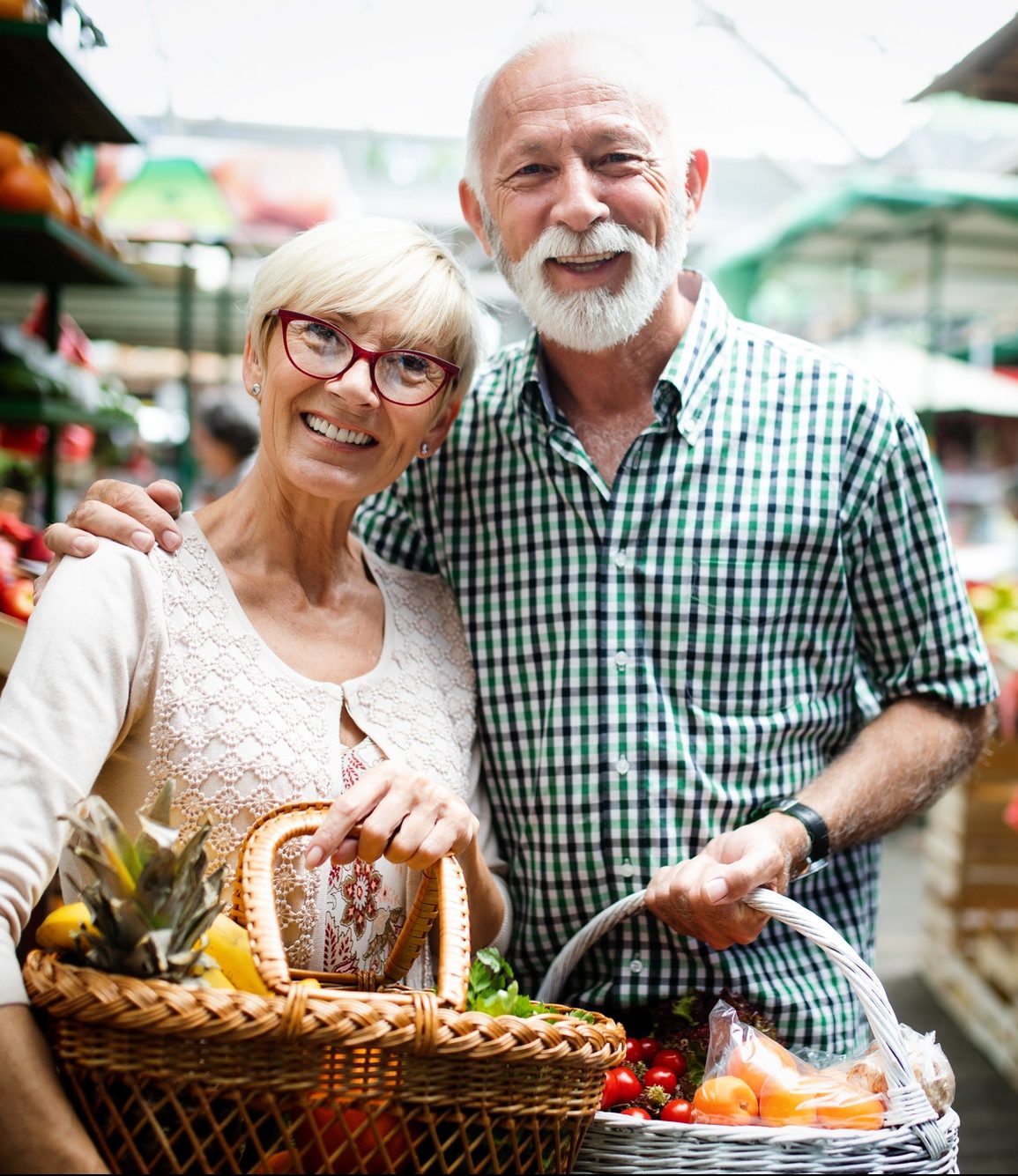 Mature shopping couple with basket on the market. Healthy diet